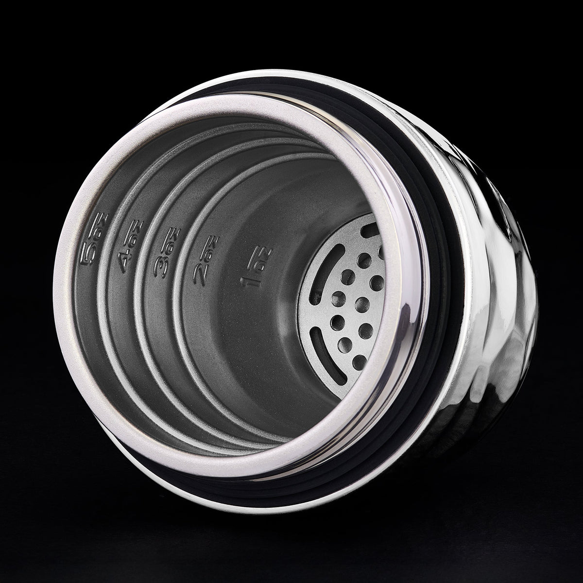 Close-up of a hexclad cocktail shaker top showing the inside with a black background